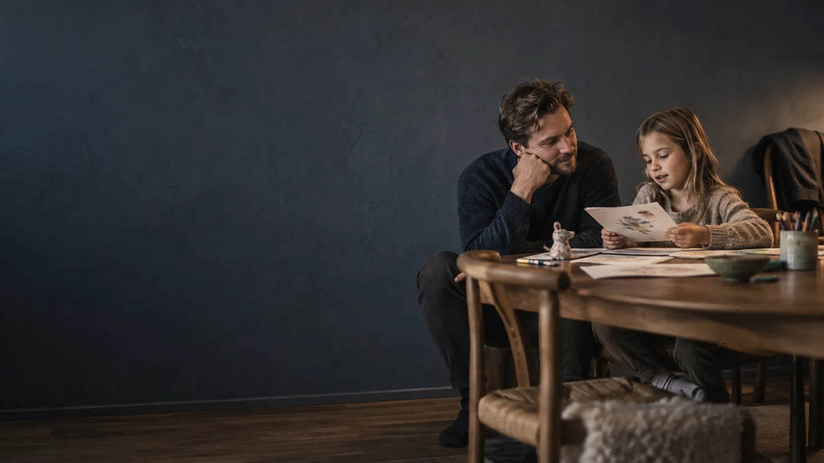 Working father sharing an ordinary evening moment with his young child at home