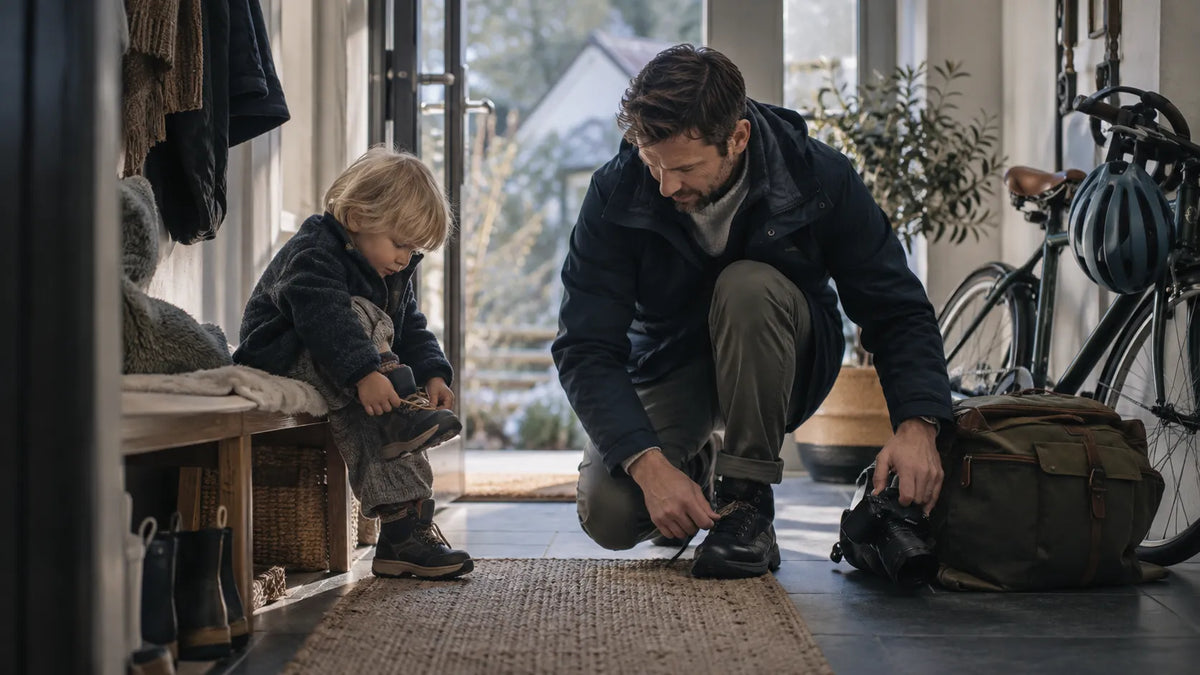 Father moving through an ordinary family moment with subtle traces of both his personal life and fatherhood around him.