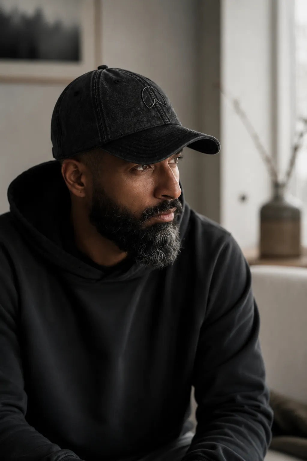 Man wearing the BRTLS Expressions Vintage Cap Black in a refined minimalist interior inspired by modern fatherhood.