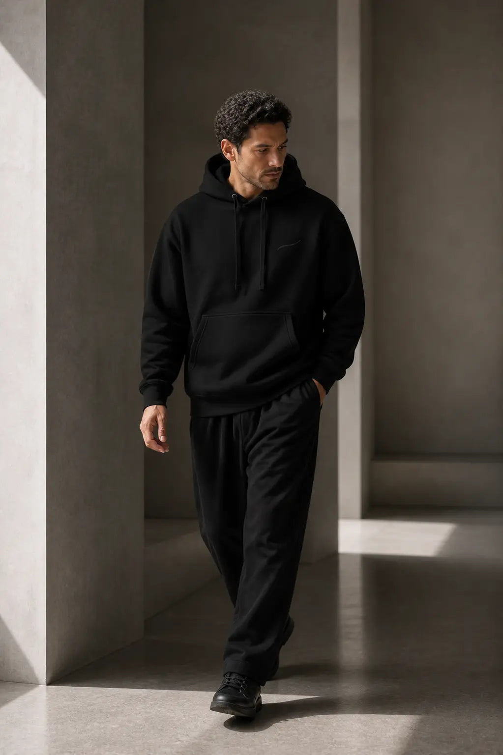 BRTLS Core Hoodie Black worn during natural movement showcasing comfort structure and everyday versatility