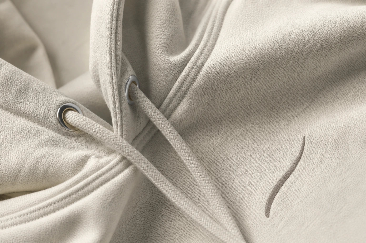 Close-up detail of the tonal embroidery and premium fabric of the BRTLS Core Hoodie Bone