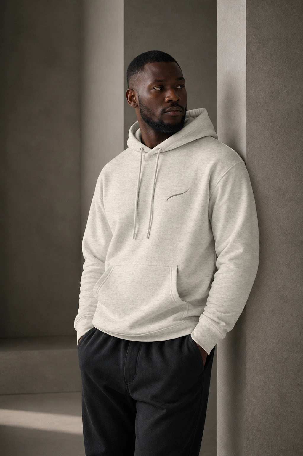 Man wearing the BRTLS Core Hoodie Bone in a minimalist architectural interior