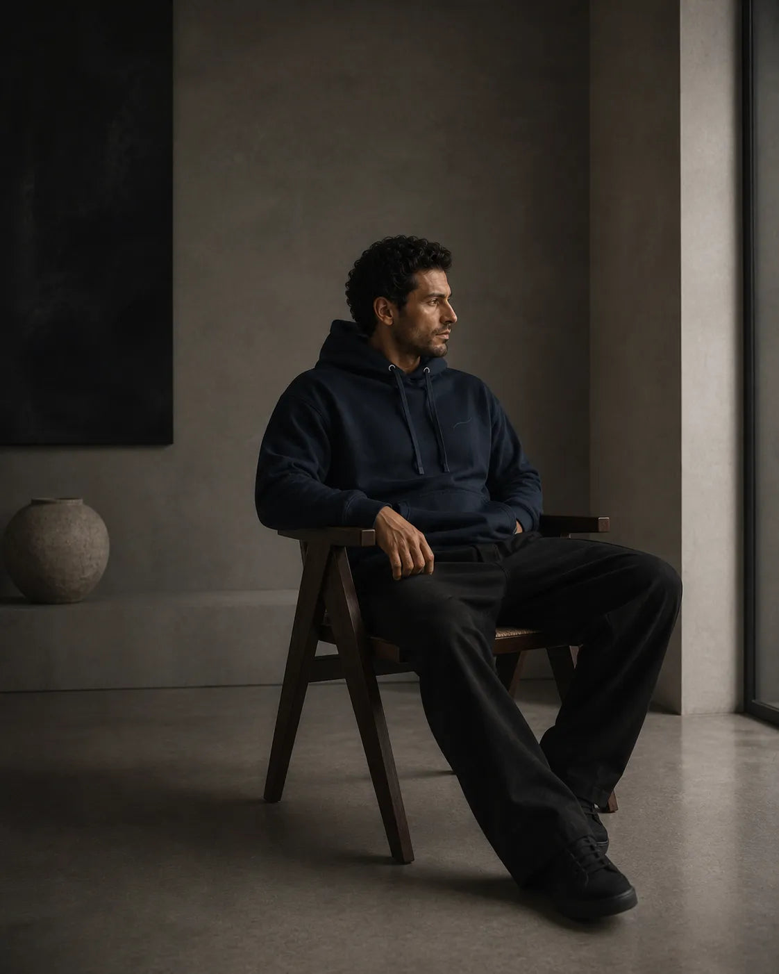 Man wearing the BRTLS Core Navy Hoodie in a refined interior, reflecting intentional living and modern masculinity