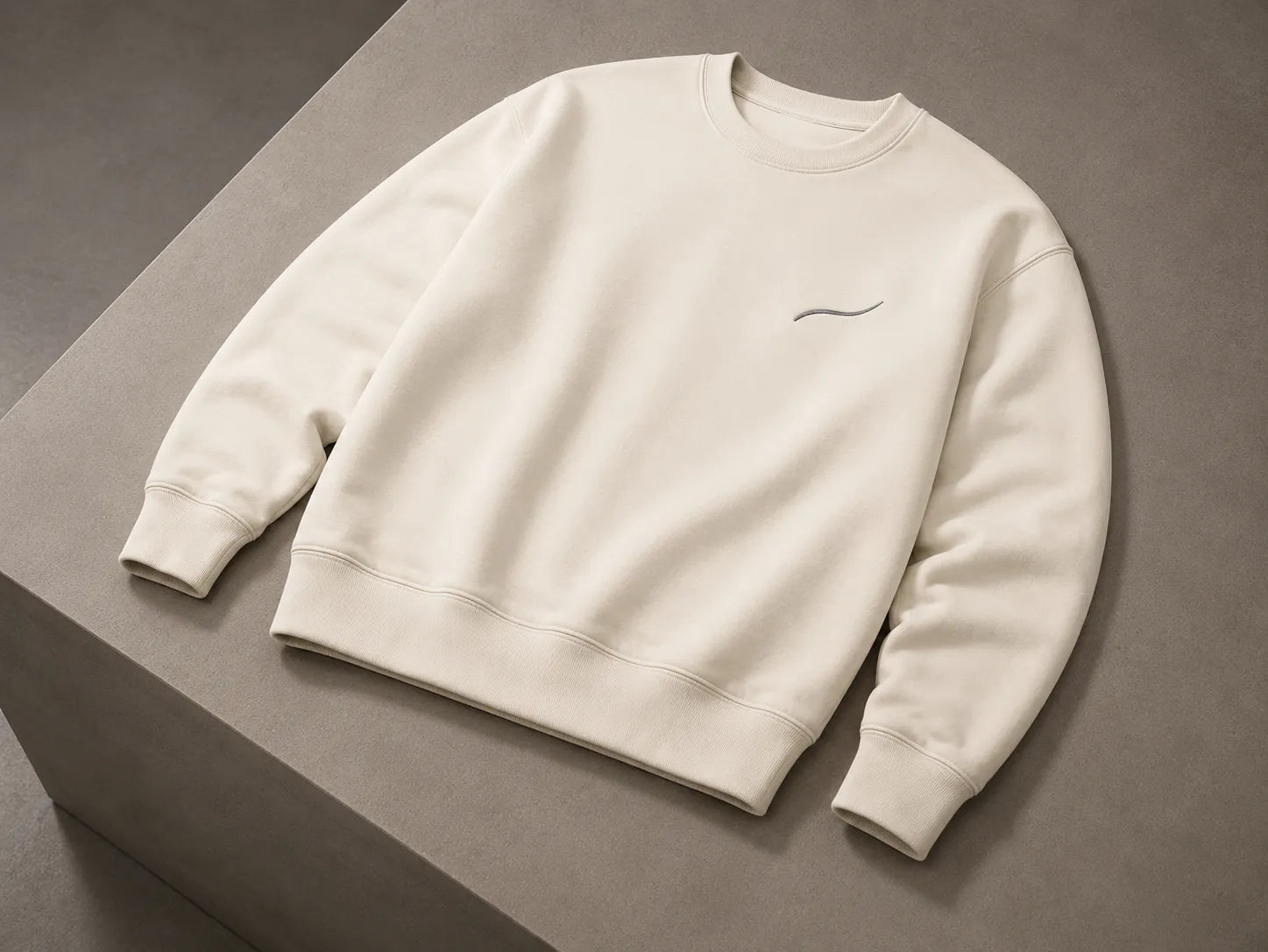 BRTLS Core Sweatshirt Bone met tonale signature embroidery, premium heavyweight fleece constructie en minimalistisch design op een neutrale stenen ondergrond.