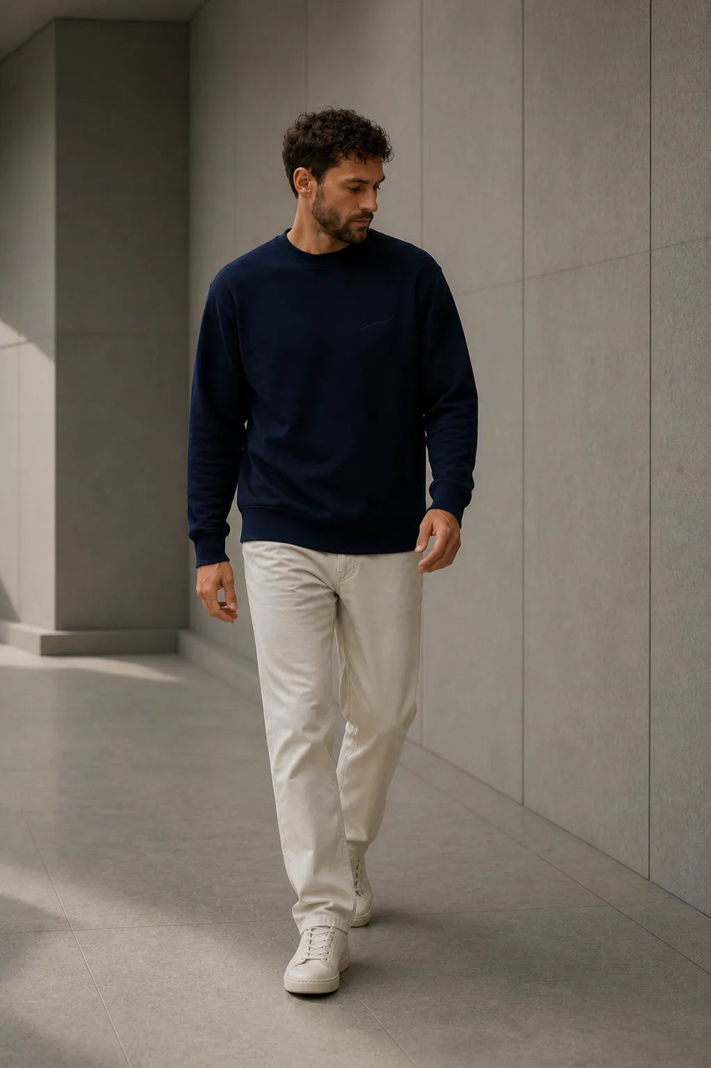 Man walking in the BRTLS Core Sweatshirt Navy, demonstrating everyday comfort, versatility and refined modern styling.