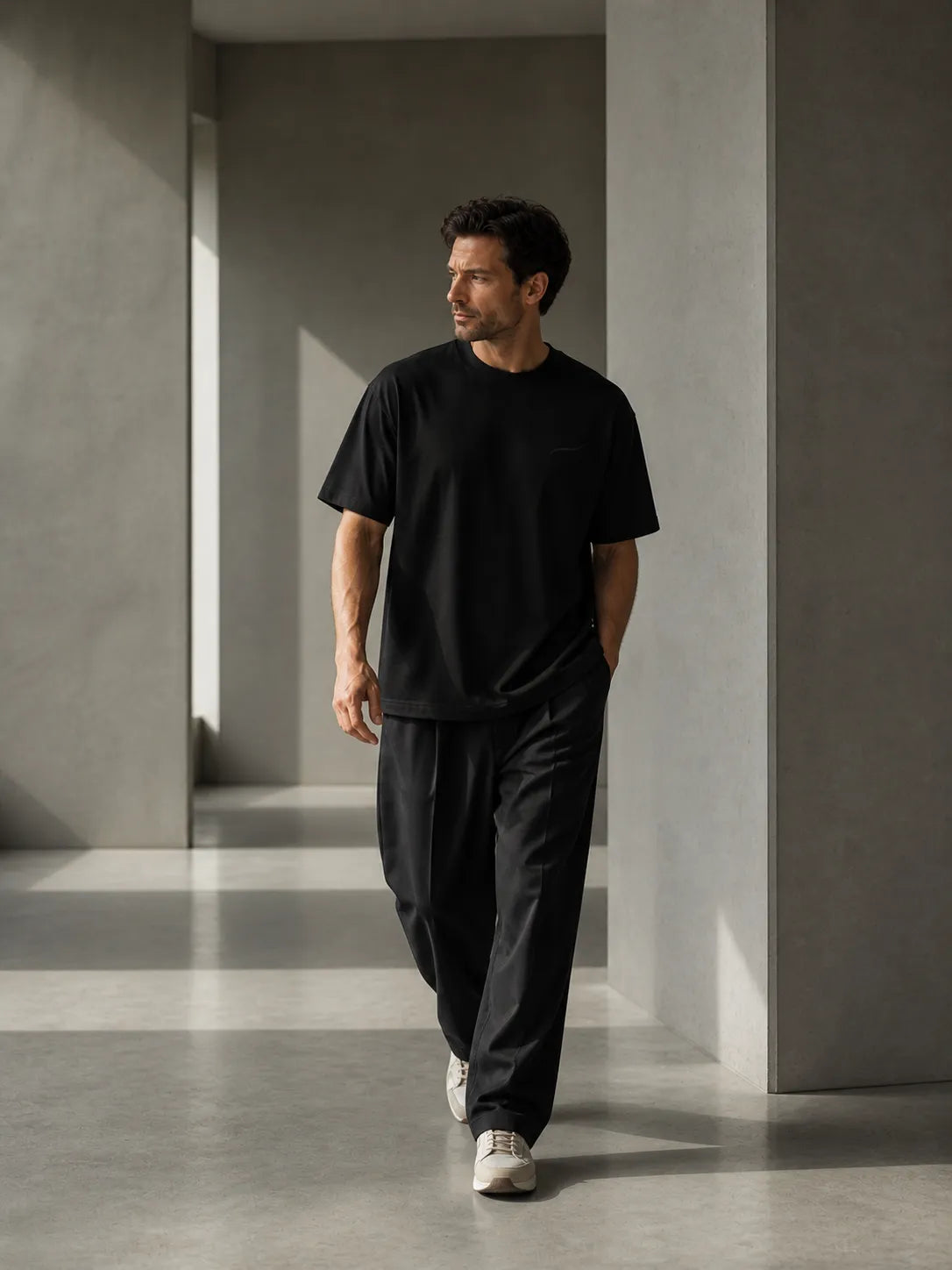 Man walking in the BRTLS Core Tee Black demonstrating comfort, movement and understated everyday confidence.
