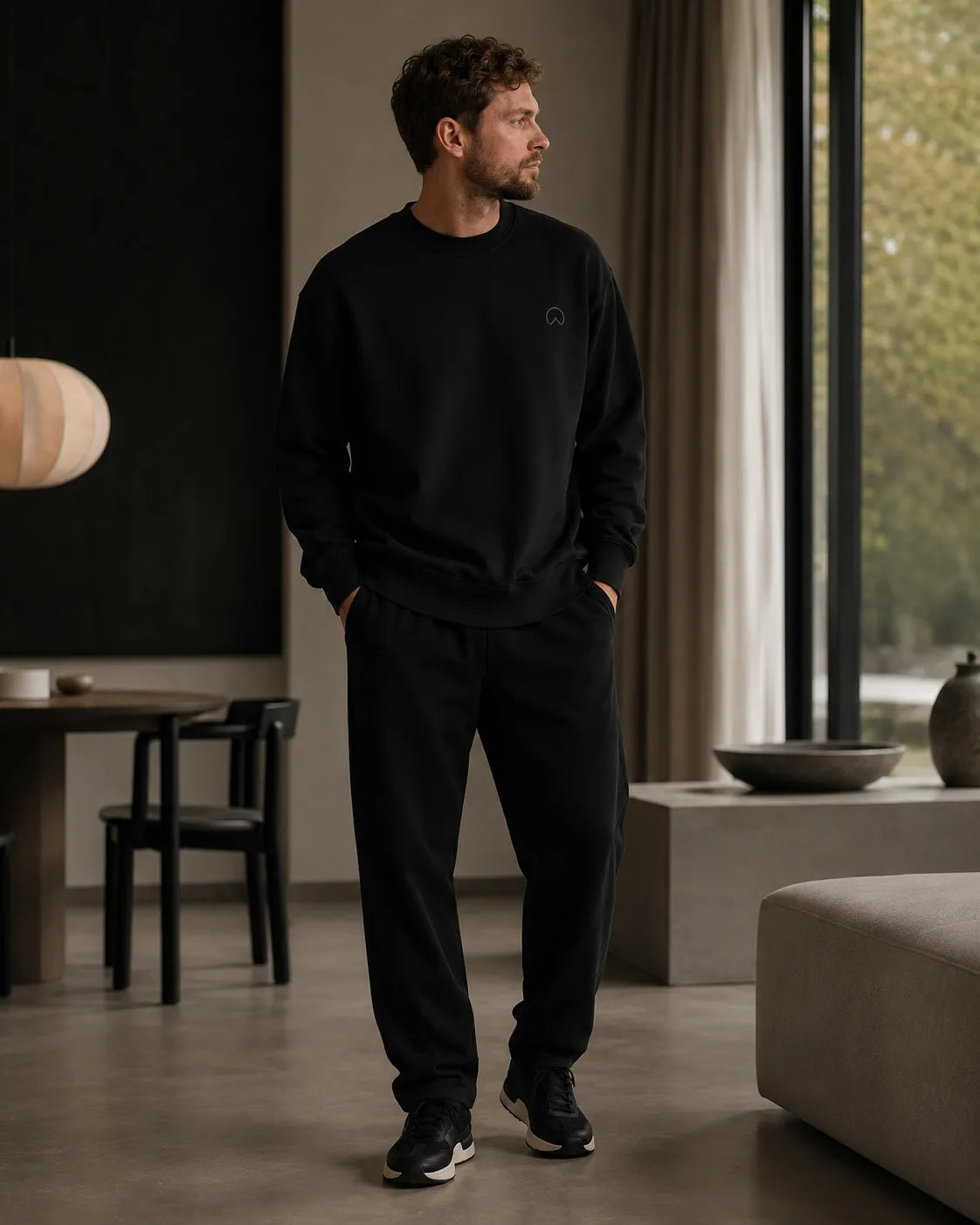 Close-up editorial presentation of the black BRTLS Own Your Presence sweatshirt featuring tonal artwork, heavyweight fleece construction and refined premium detailing