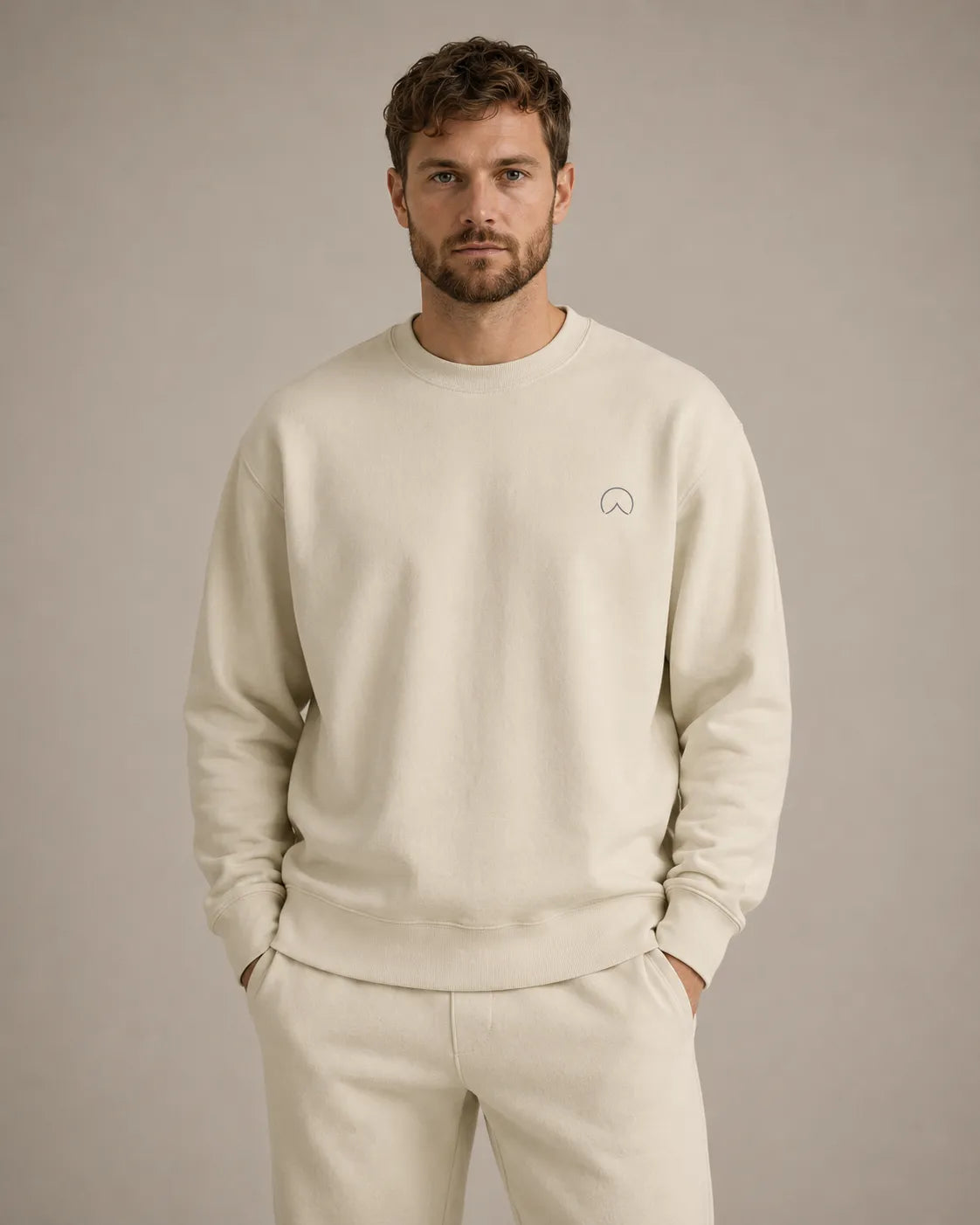 Man wearing the BRTLS Own Your Presence sweatshirt in bone with relaxed Scandinavian styling