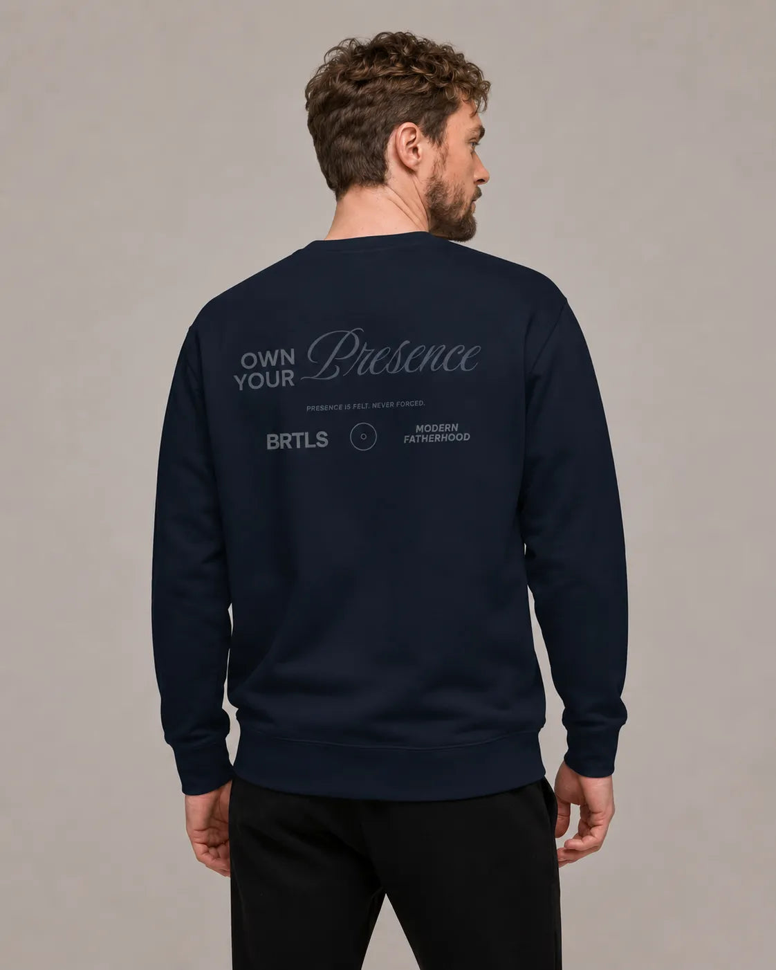 Back view of BRTLS Own Your Presence Navy Sweatshirt featuring tonal typography artwork and modern fatherhood aesthetic