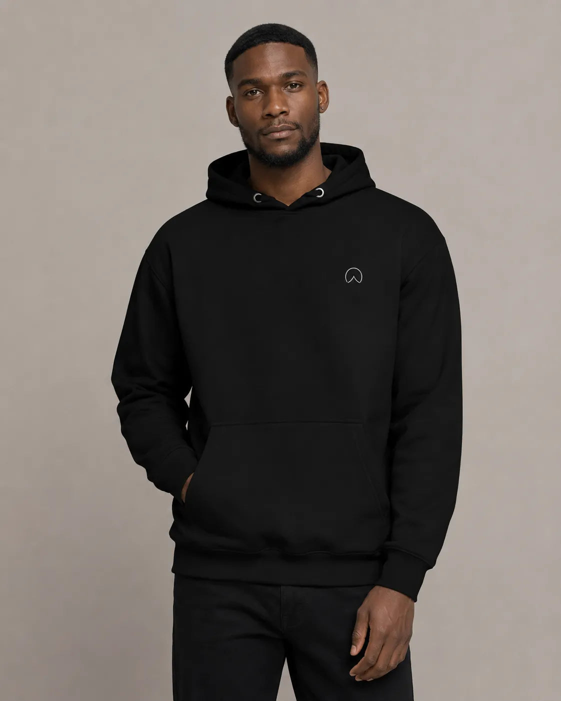 Front-facing model wearing The Presence Hoodie Black by BRTLS in a minimalist editorial studio setting