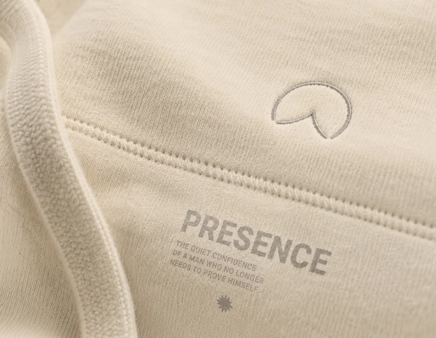 Close-up detail of the bone BRTLS Presence Hoodie showing premium heavyweight fabric texture and tonal embroidery