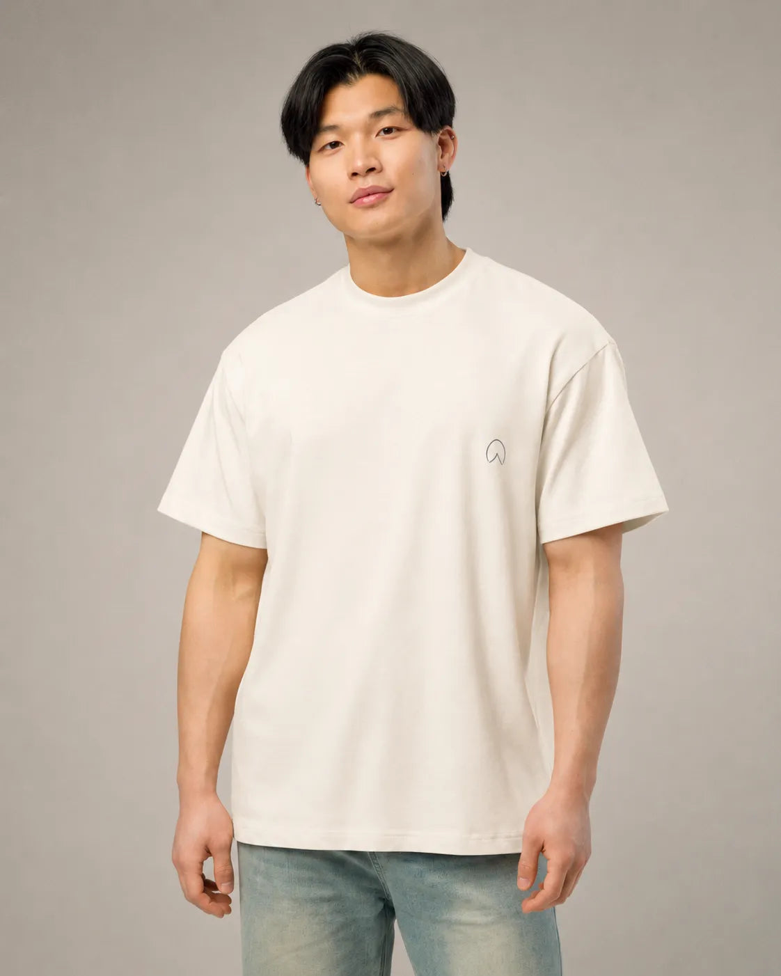 Model wearing the BRTLS Presence Refined Tee in Vintage White with a relaxed oversized heavyweight fit and minimalist tonal embroidery.