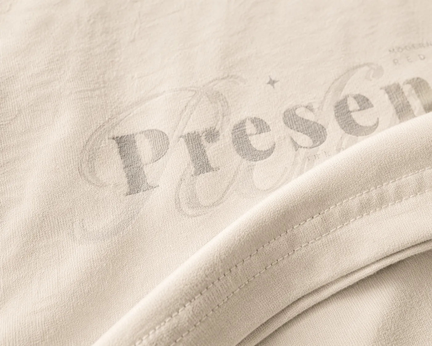 Close-up detail of the BRTLS Presence Refined Tee in Vintage White showcasing premium heavyweight cotton texture, tonal print layering and refined stitching.