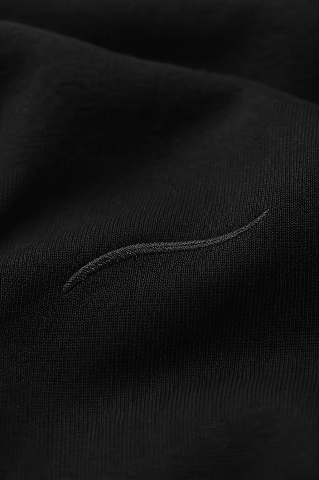 Close-up detail of tonal BRTLS signature embroidery on the Core Hoodie Black