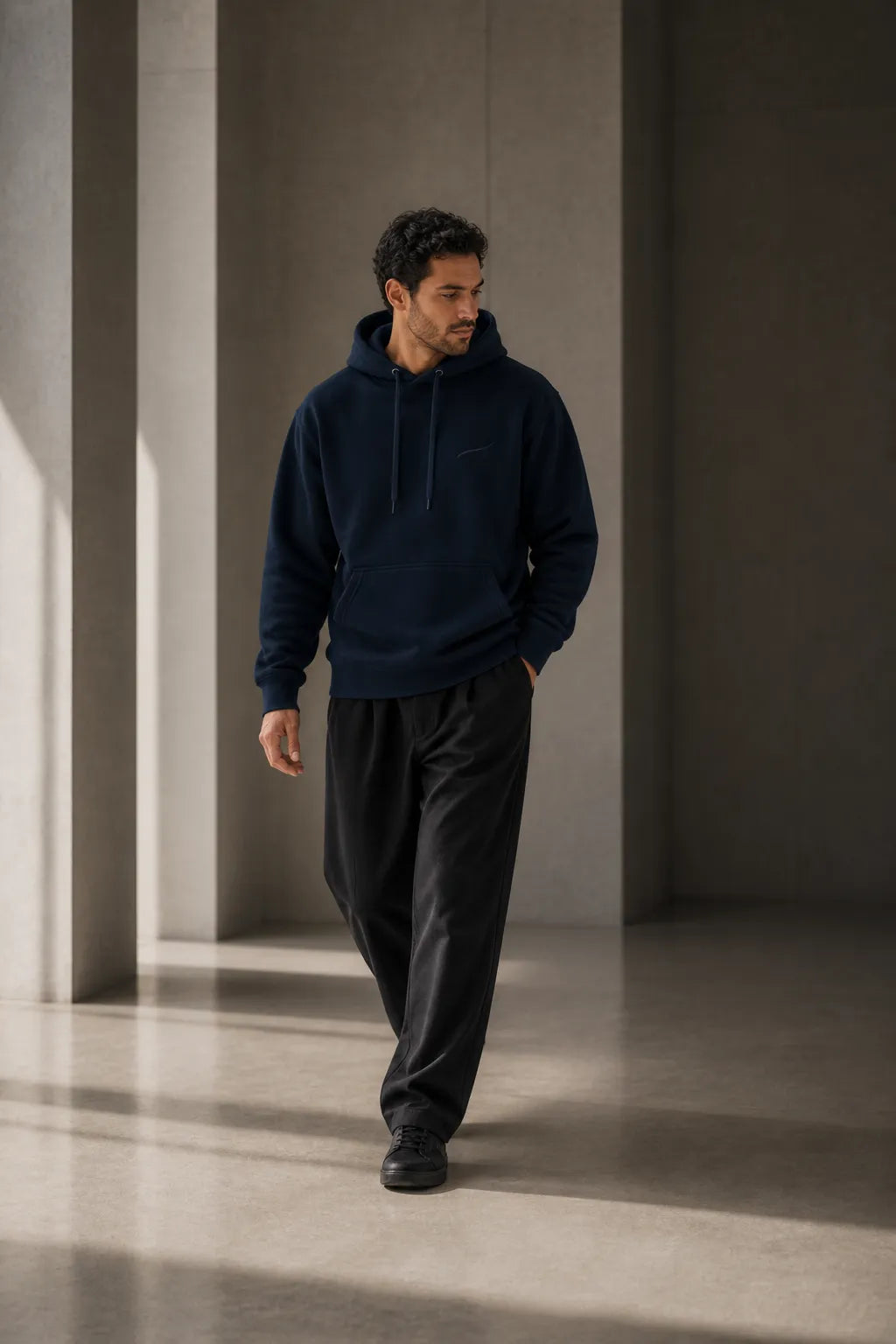 Man wearing the BRTLS Core Navy Hoodie during a calm moment of movement and presence