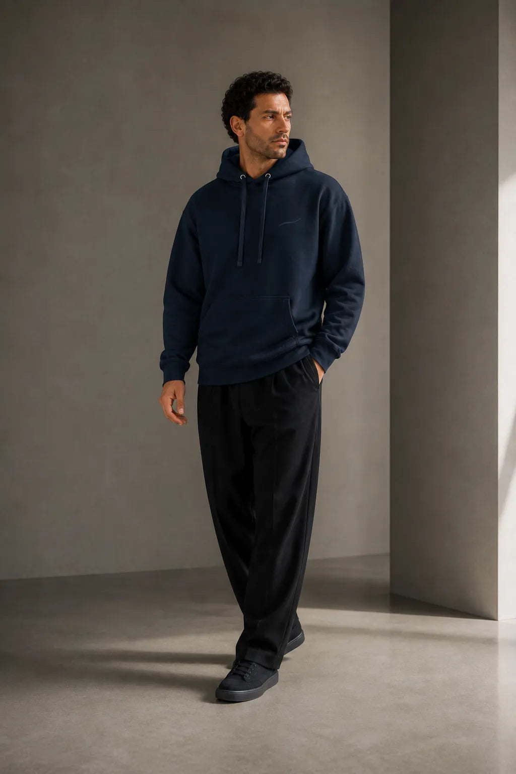 Man walking in the BRTLS Core Navy Hoodie showcasing the relaxed fit and premium heavyweight fabric
