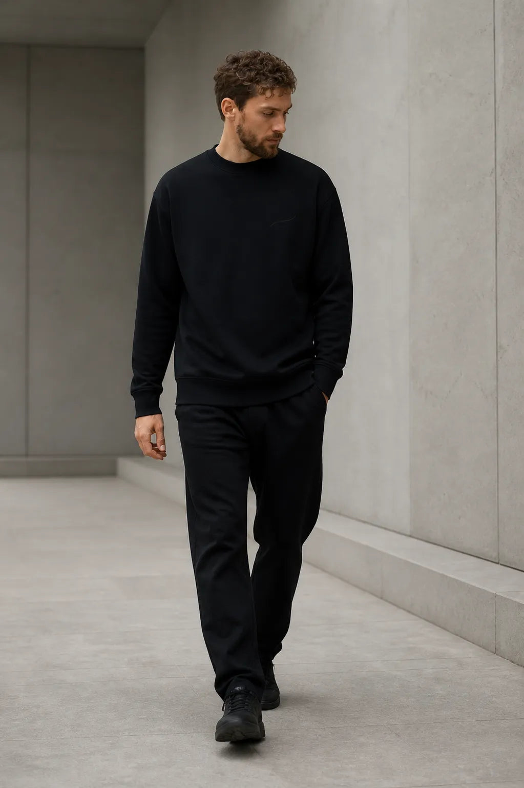 Man walking in the BRTLS Core Sweatshirt Black highlighting everyday versatility and modern fit