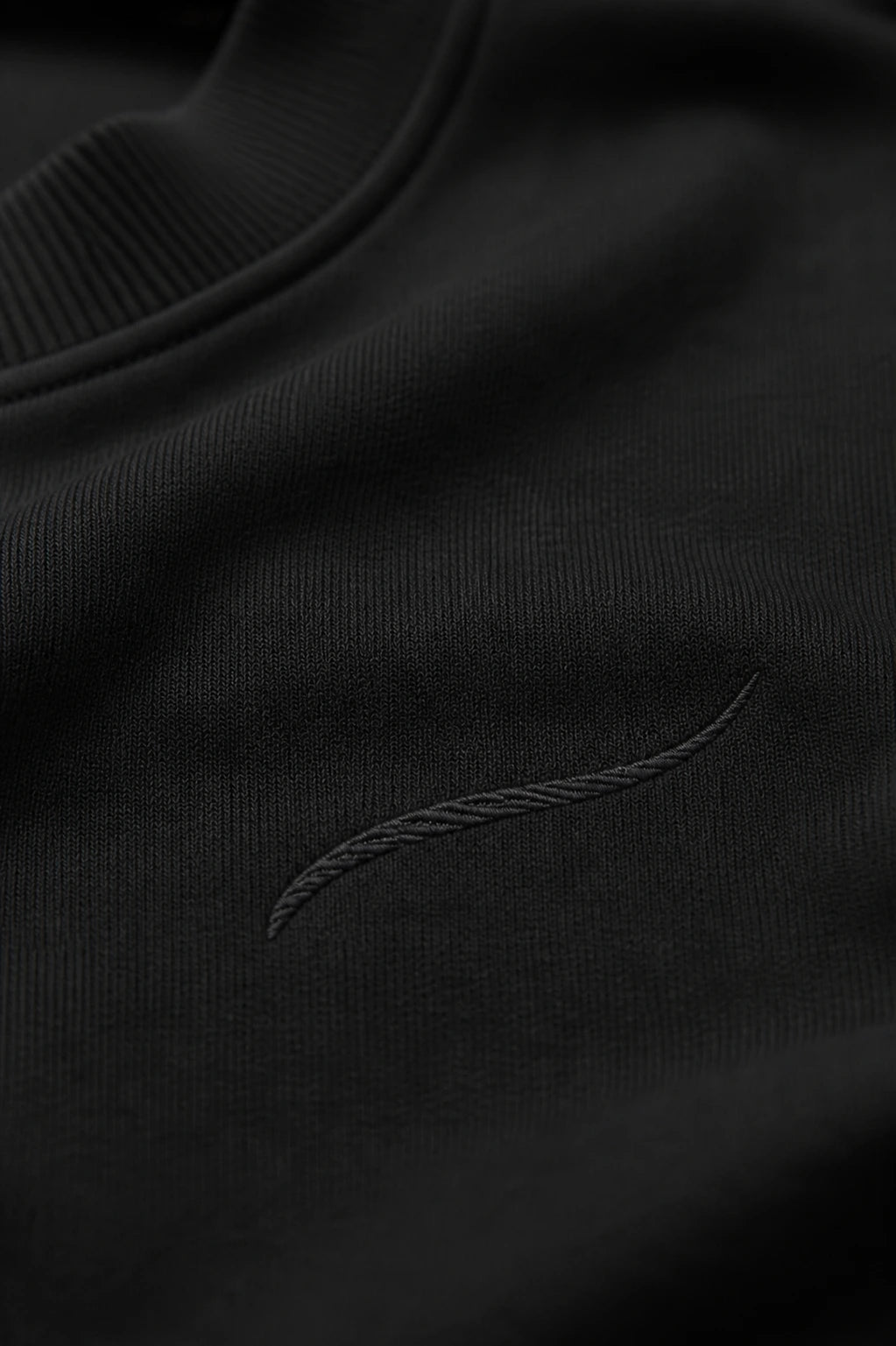 Close-up of the tonal BRTLS signature embroidery on the Core Sweatshirt Black