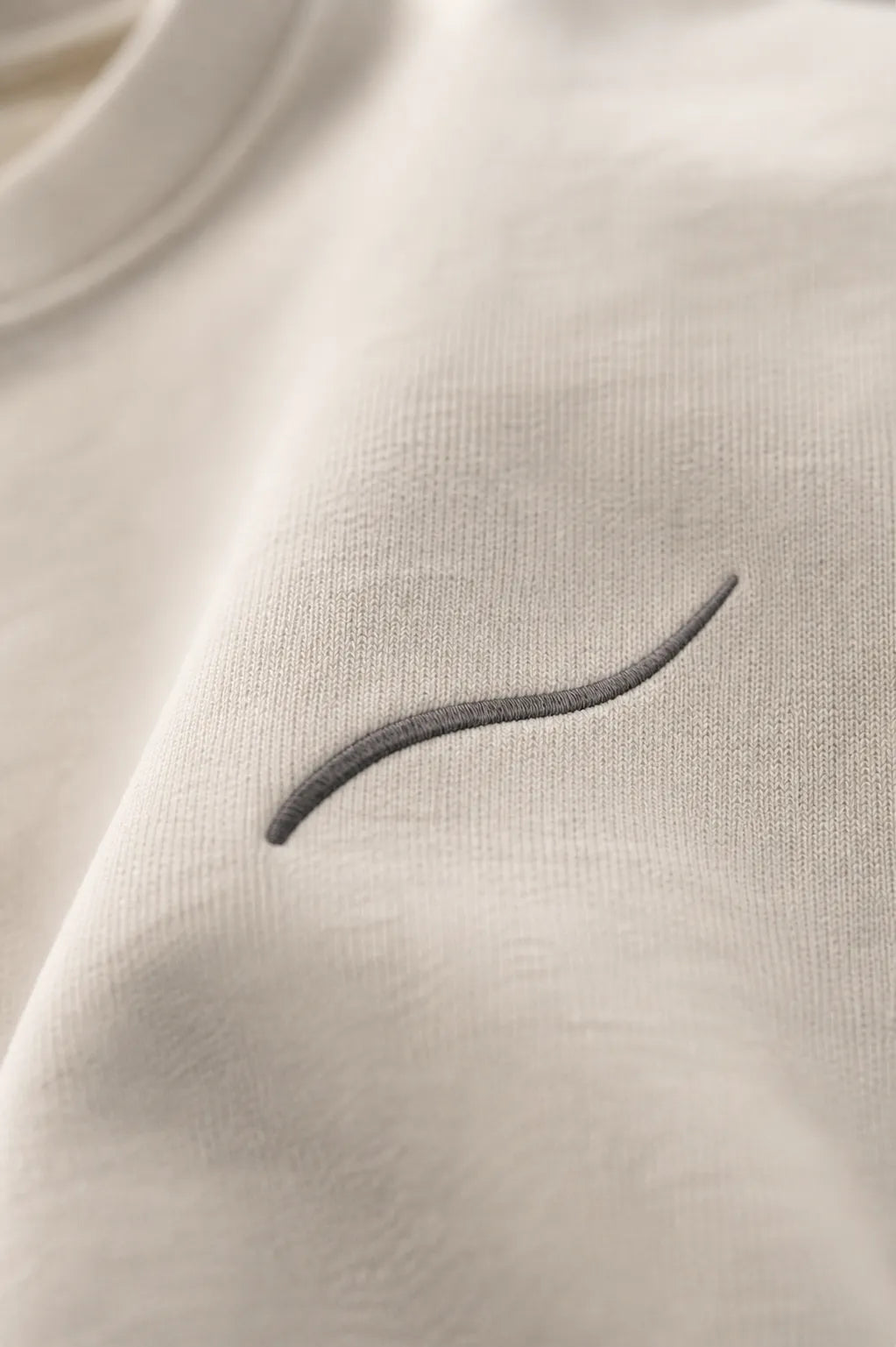 Close-up of the tonal BRTLS signature embroidery on the Core Sweatshirt Bone, highlighting premium craftsmanship and minimalist detailing.