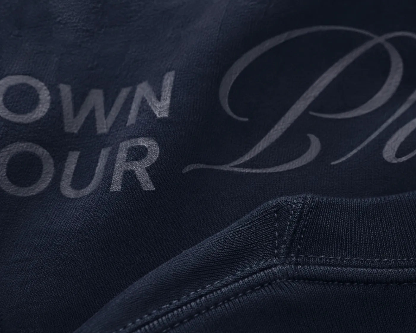 Close-up detail of tonal typography print and heavyweight fabric texture on BRTLS Own Your Presence Navy Sweatshirt