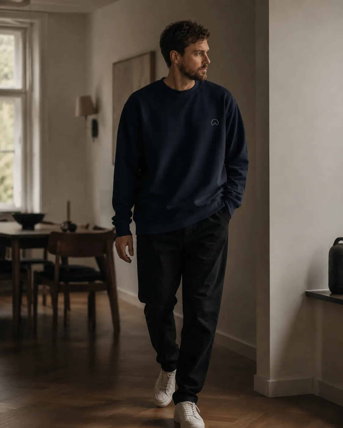 Lifestyle image of man wearing BRTLS Own Your Presence Navy Sweatshirt with relaxed silhouette and quiet luxury aesthetic
