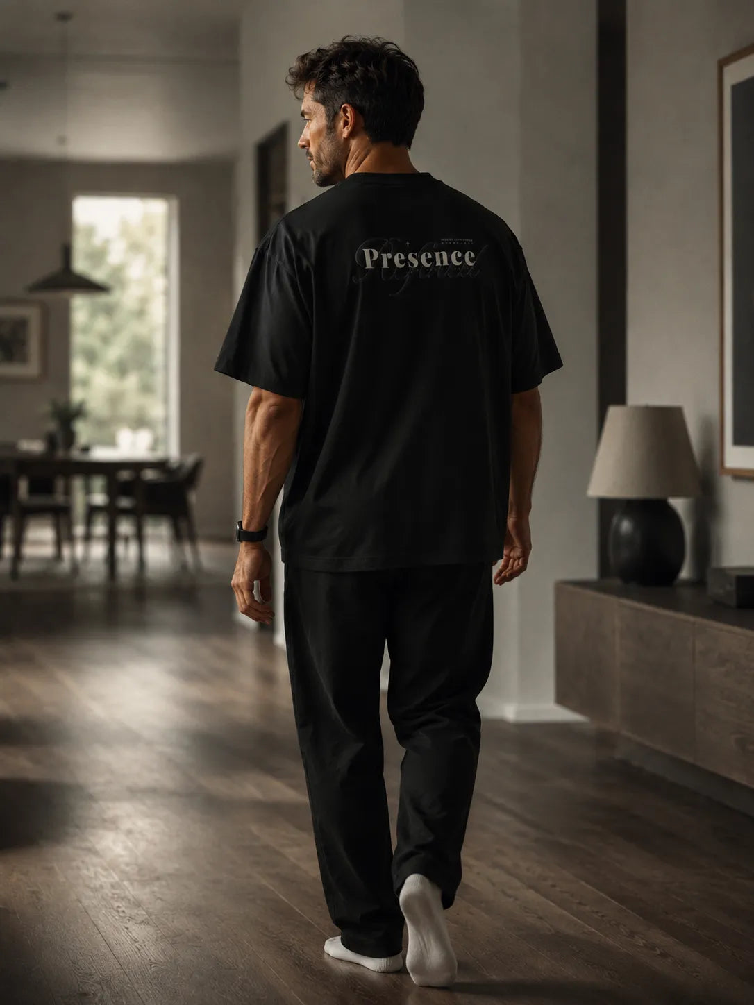 Lifestyle image of a man walking in the BRTLS Refined Presence Tee Black oversized heavyweight t-shirt